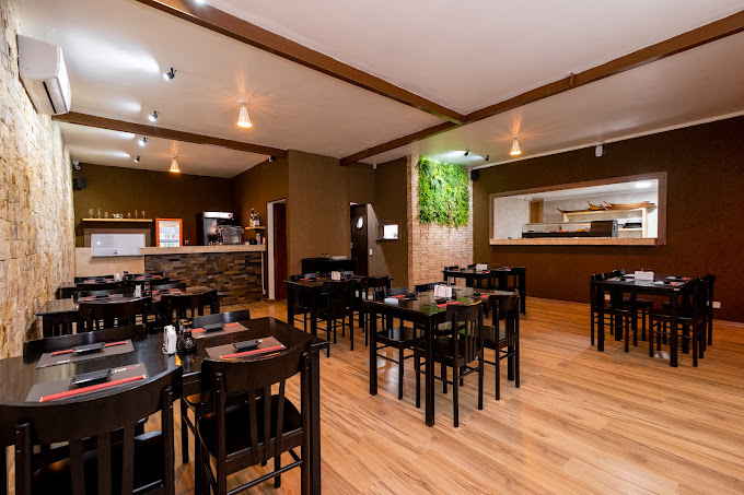 Salão principal do Noiê Sushi com mesas escuras e jardim vertical